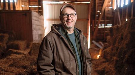 Dr. Allen Dietz standing in a barn on a farm