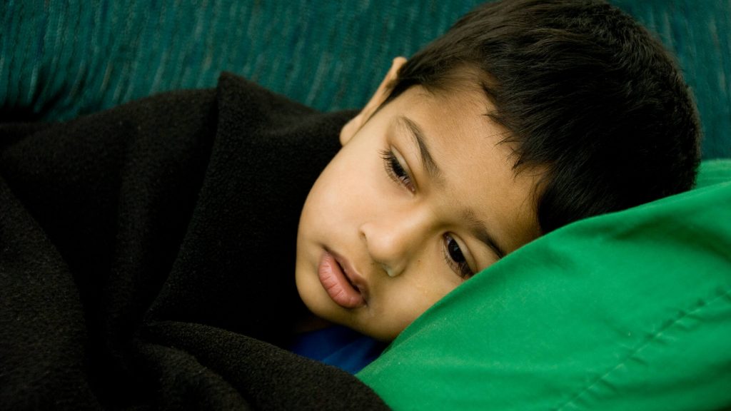 Un niño enfermo y muy bien parecido descansa