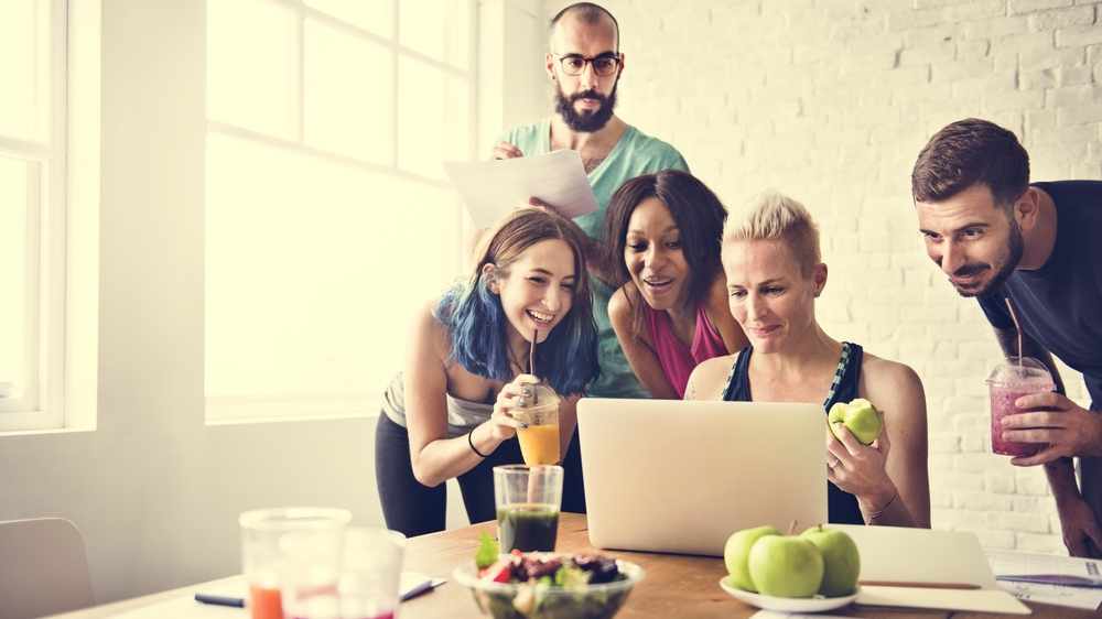 Group of millennials eating healthy food while researching health