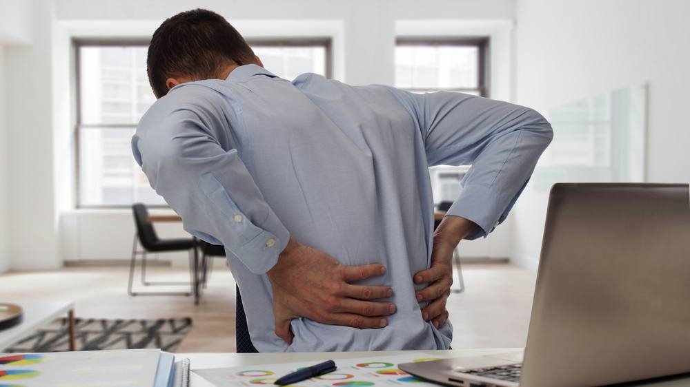 Businessman at desk with back pain