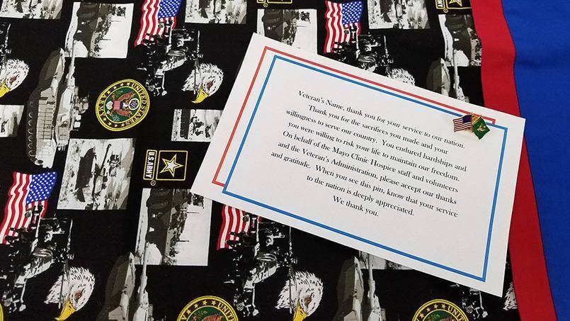 Veteran pinning items on a black cloth with a thank you note
