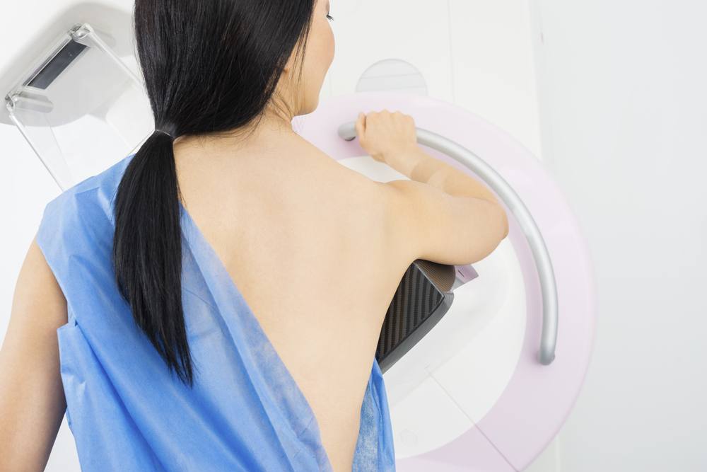 Woman Standing In Front Of Mammography Machine