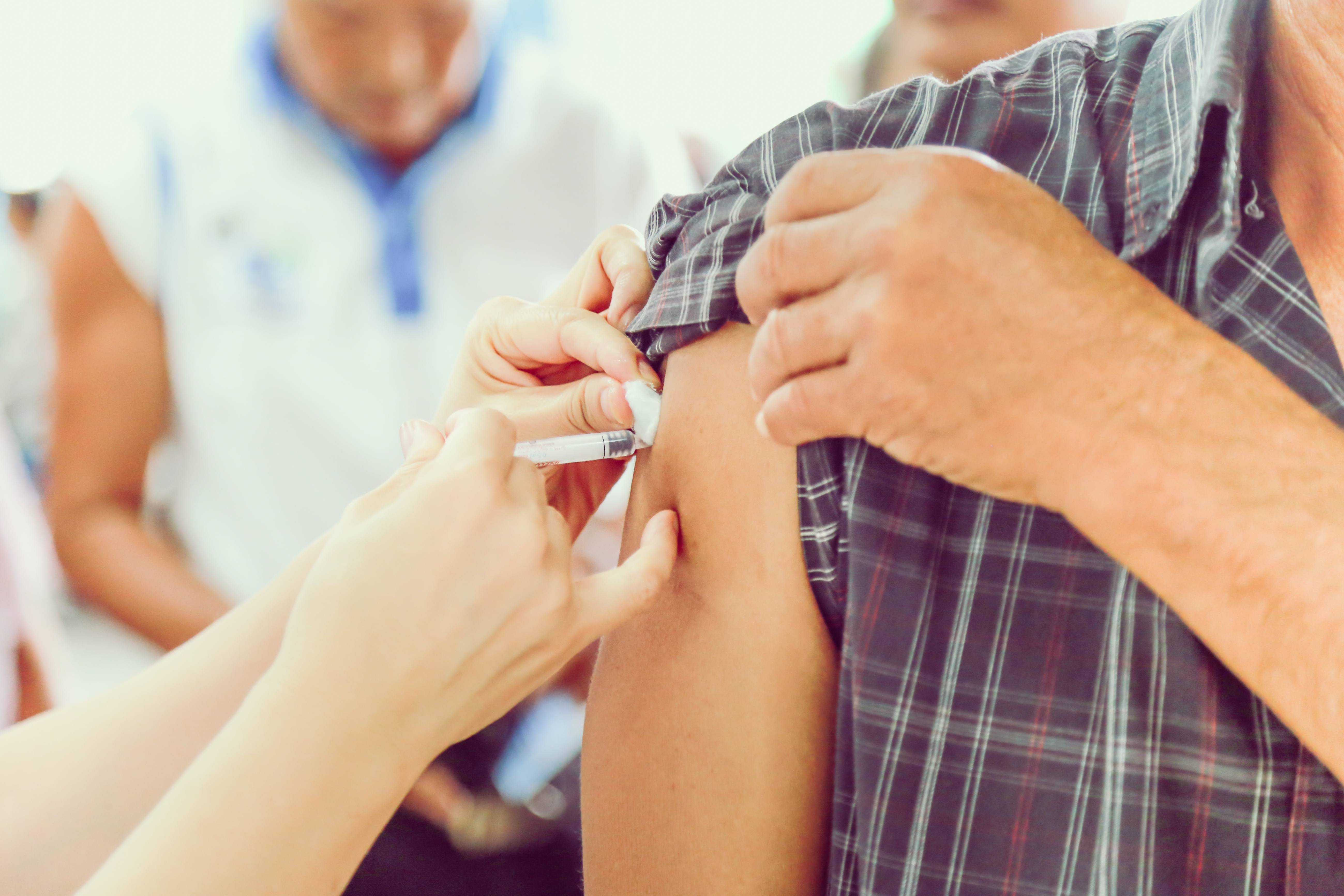 a person getting vaccinated by a healthcare person giving a flu shot