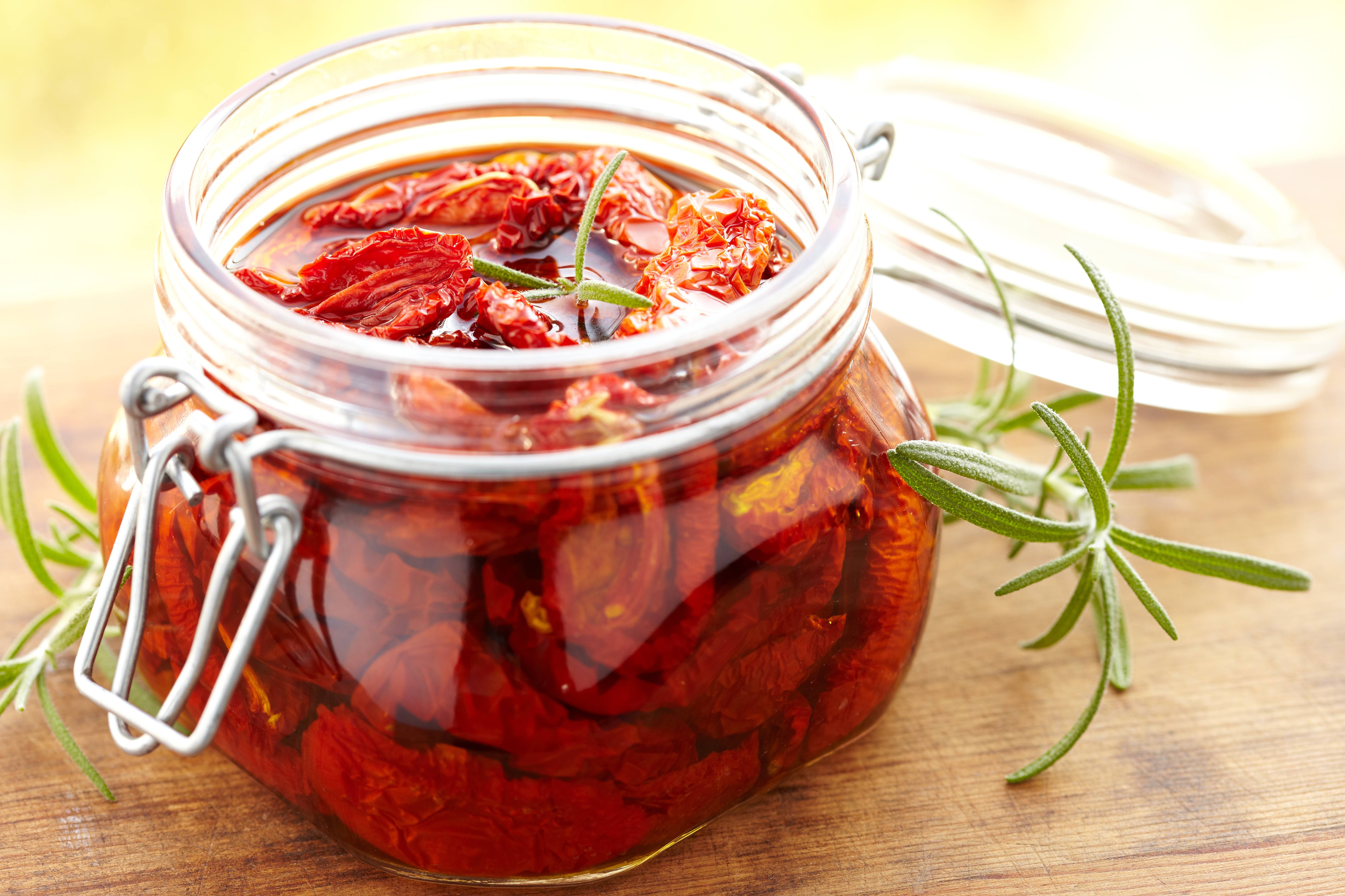 a jar of sundried tomatoes marinating for a vegetable pesto spread