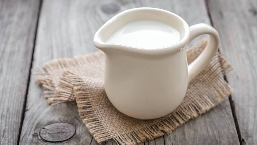 a small milk or cream pitcher sitting on a table, representing calcium intake