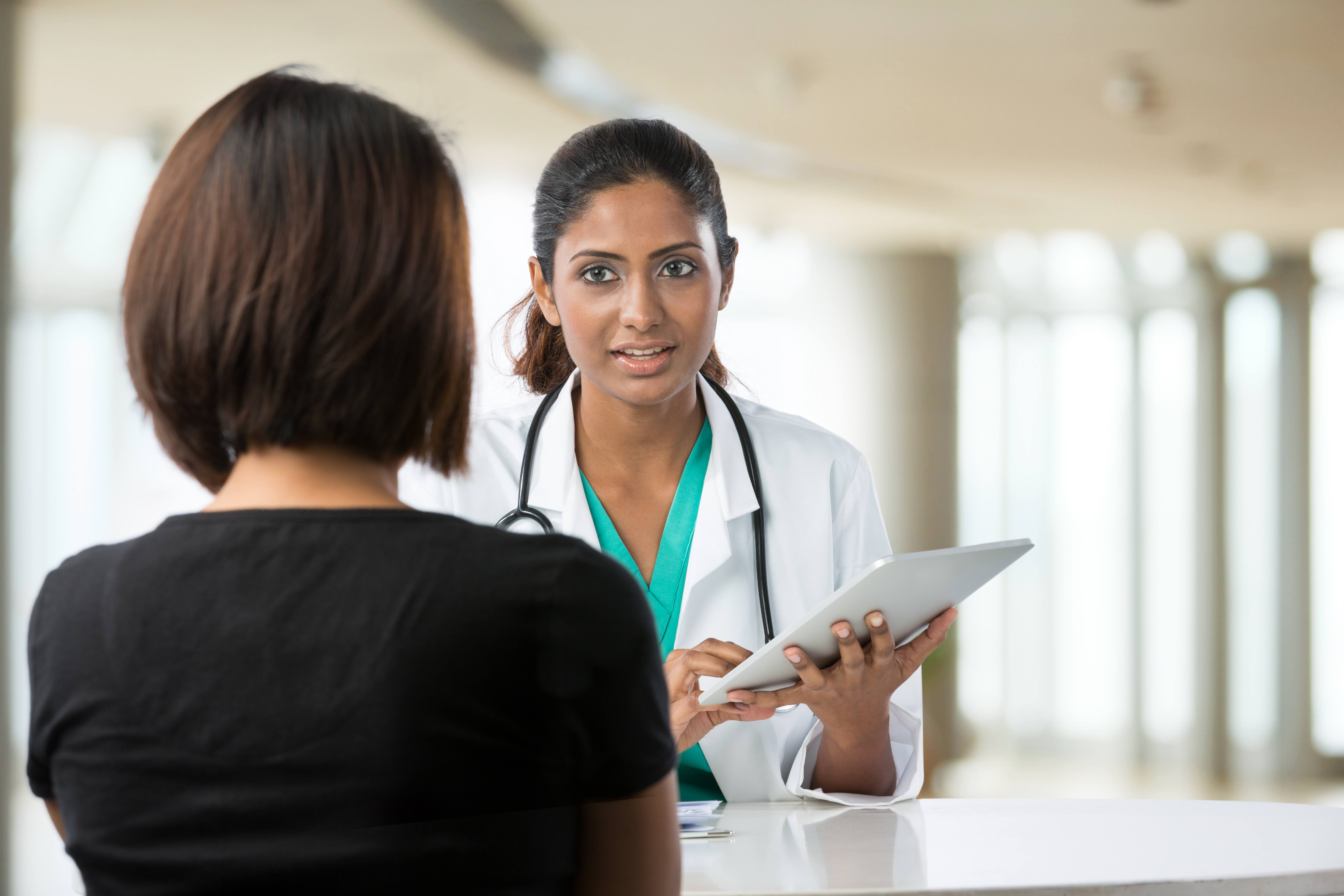doctor talking with female patient in doctors office