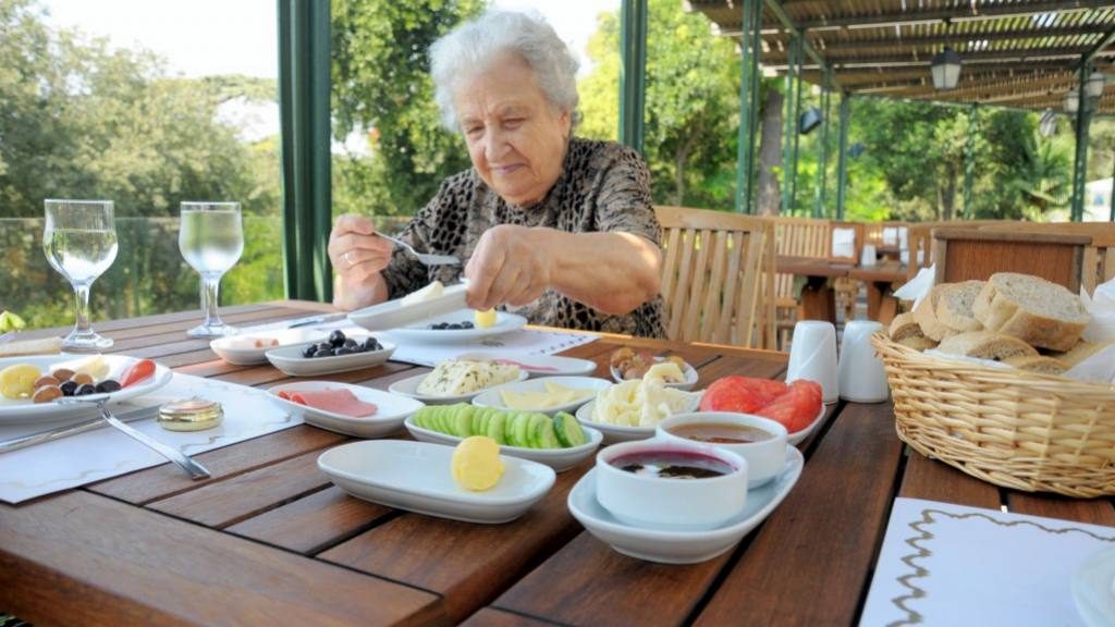 Una mujer de la tercera edad (anciana) come una comida nutritiva