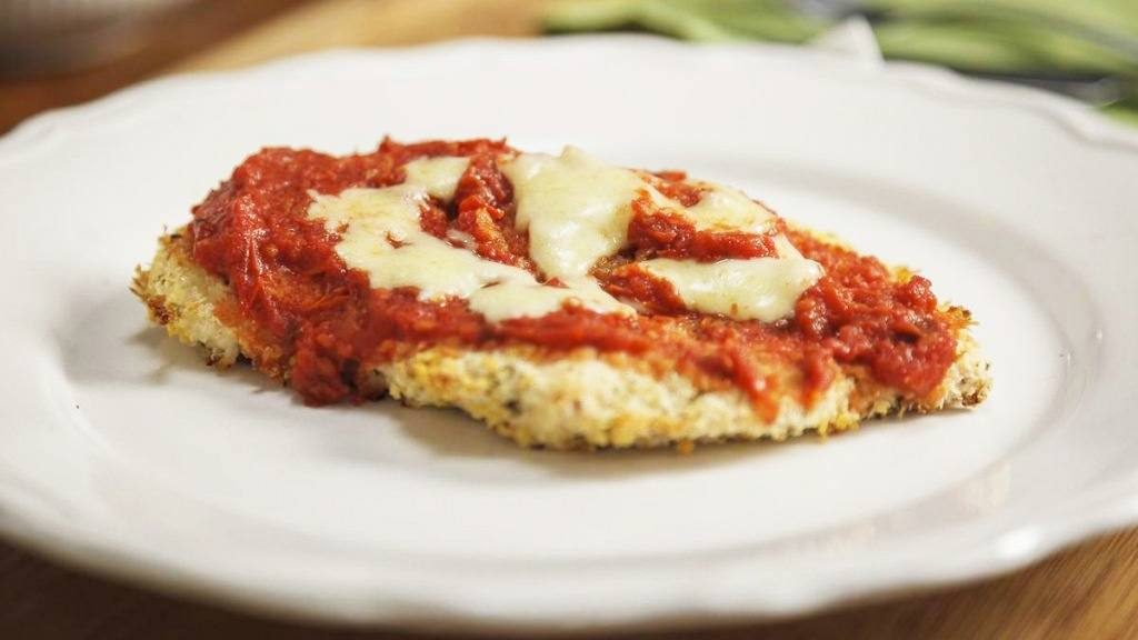 Mayo recipe of chicken Parmesan sprinkled with mozzarella cheese, on a white dinner plate