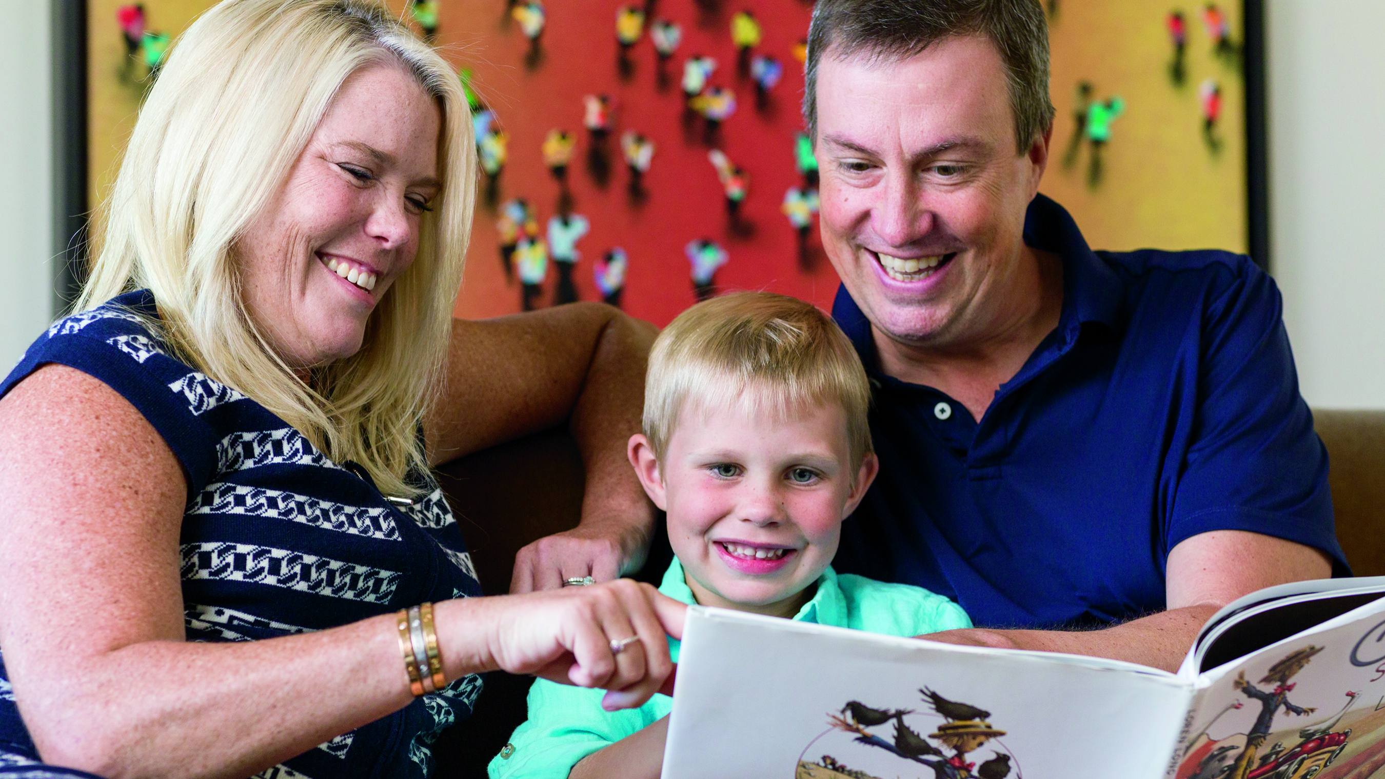 breast cancer patient Dawn Lenhardt smiling with her family and reading a children's book
