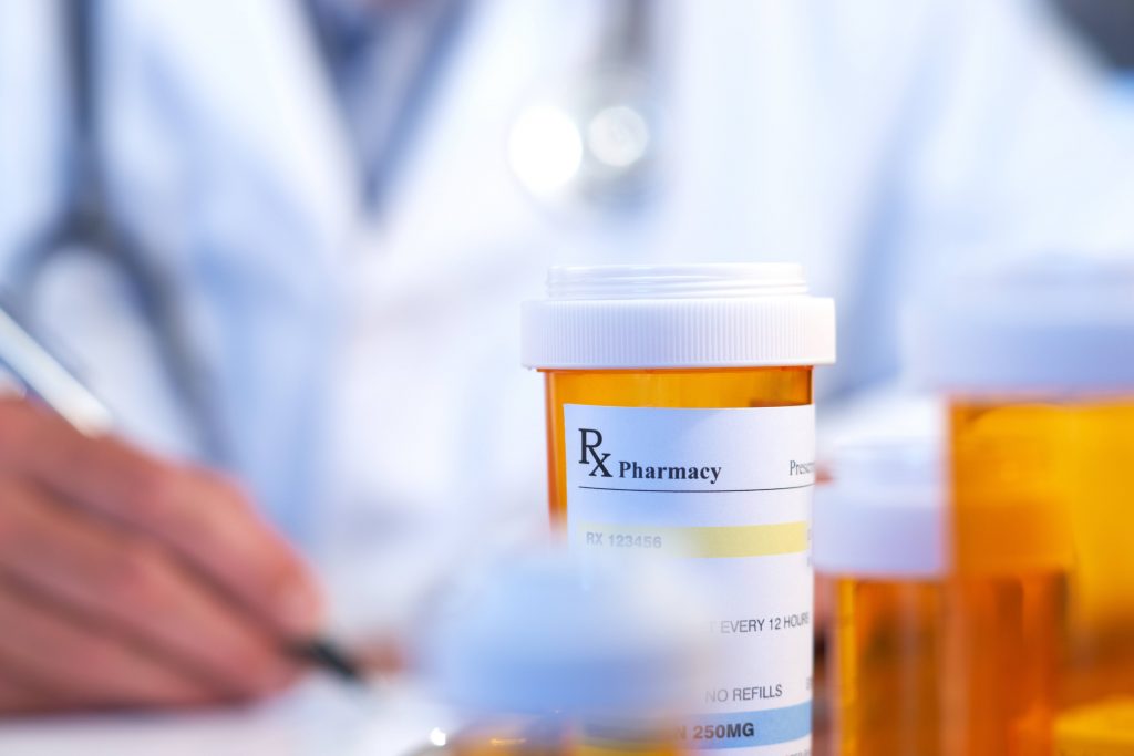 a prescription medicine pill bottle with a health care provider in the background