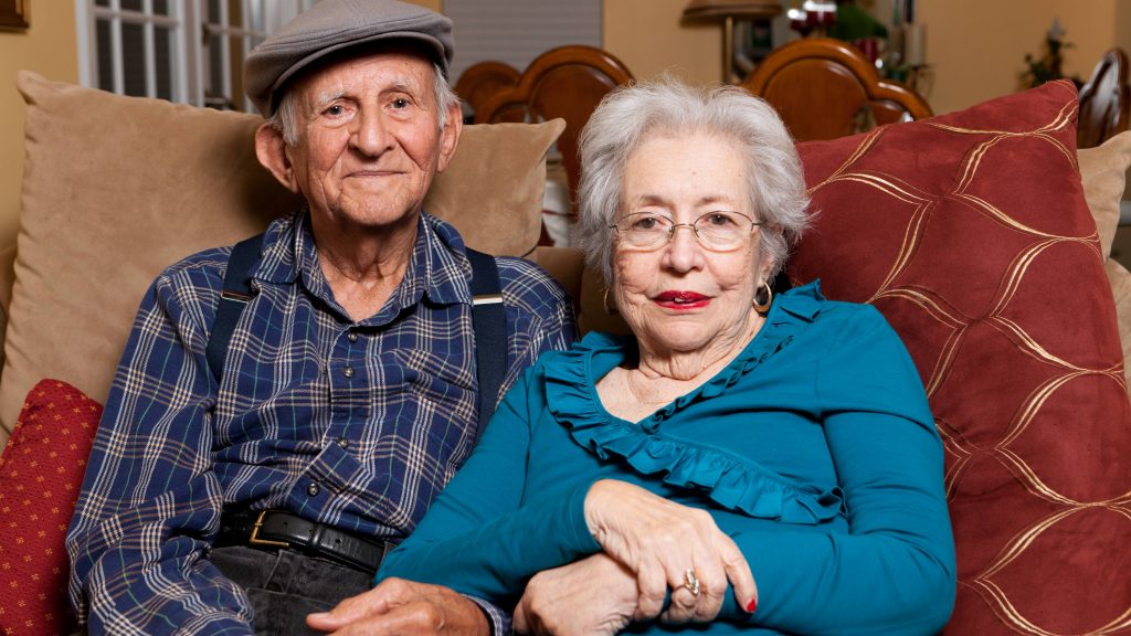 Una pareja de ancianos de más de 80 años sentados cariñosamente juntos en su casa
