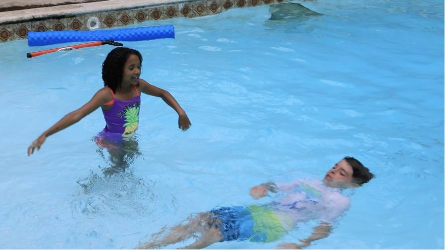 Kids in a pool swimming