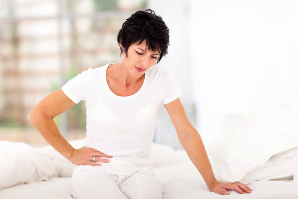 woman having stomach aches, cramps and pain - menstruation