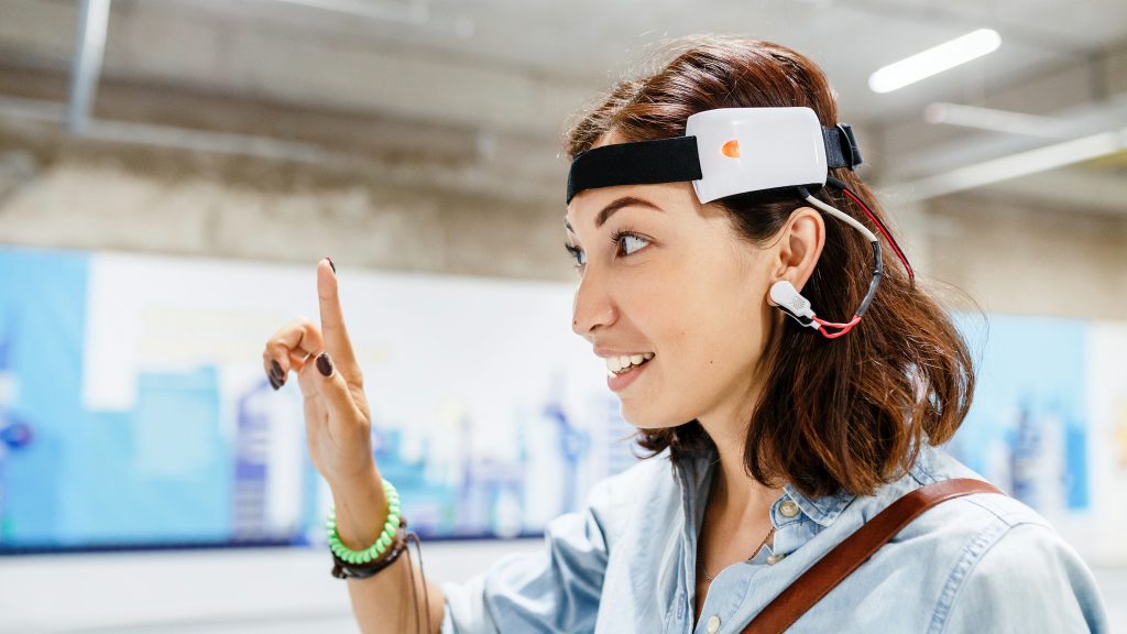 Mujer con un sensor digital conectado en la oreja para leer los impulsos cerebrales