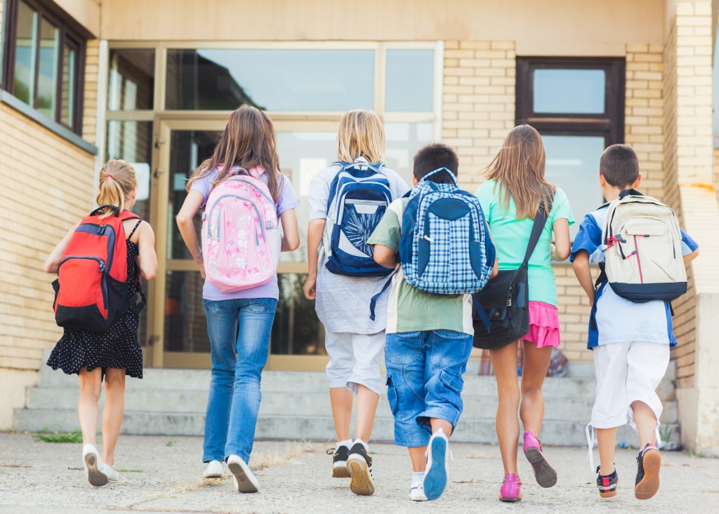 kids walking into school with backpacks