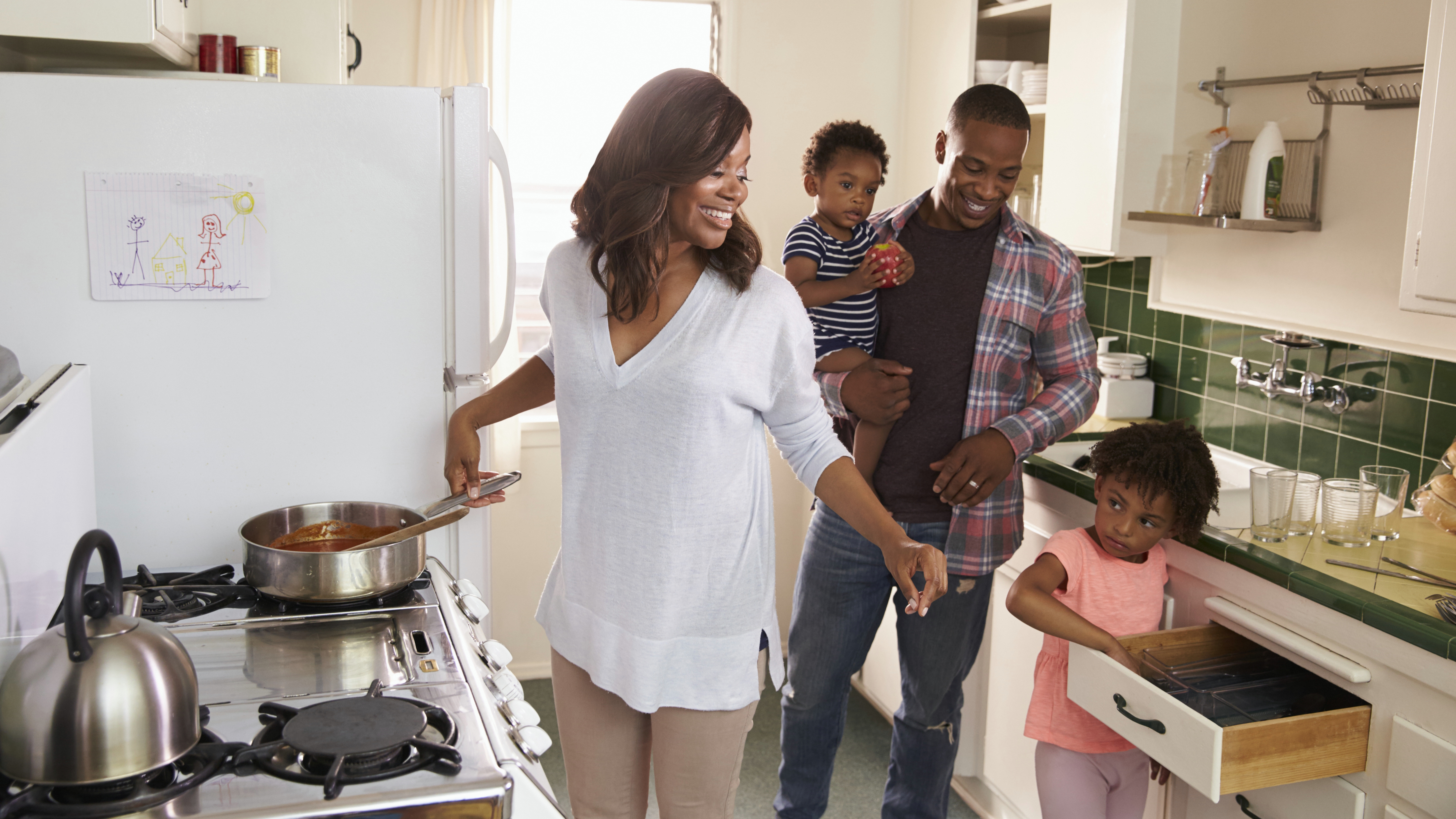 a family in the kitchen getting ready to cook and eat dinner together