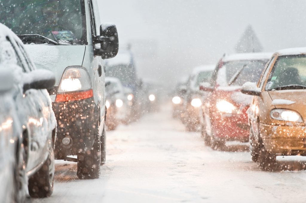 a wintry road scene with lots of traffic in the snow