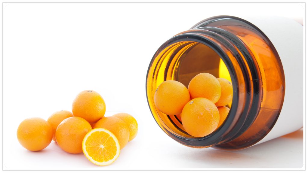 an open pill bottle on its side, spilling out oranges - vitamin C concept