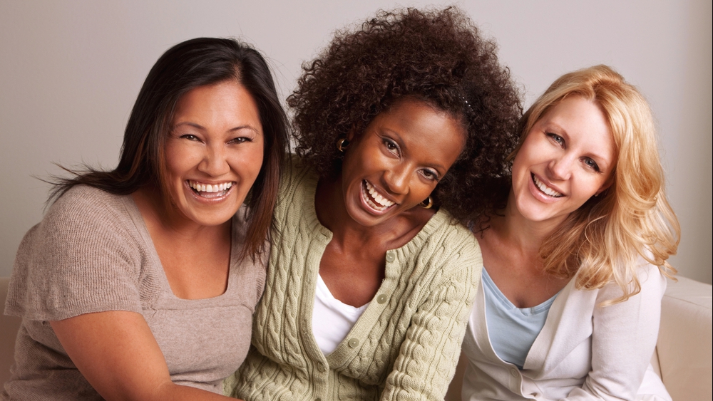 three young women laughing and smiling together