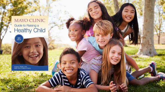 the Mayo Clinic Healthy Child Book graphic embedded in an image of a group of children laughing, smiling and playing outside in a park