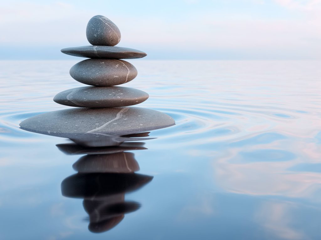 a stack of smooth stones in a pool of water, illustrating relaxation, meditation, balance, peace