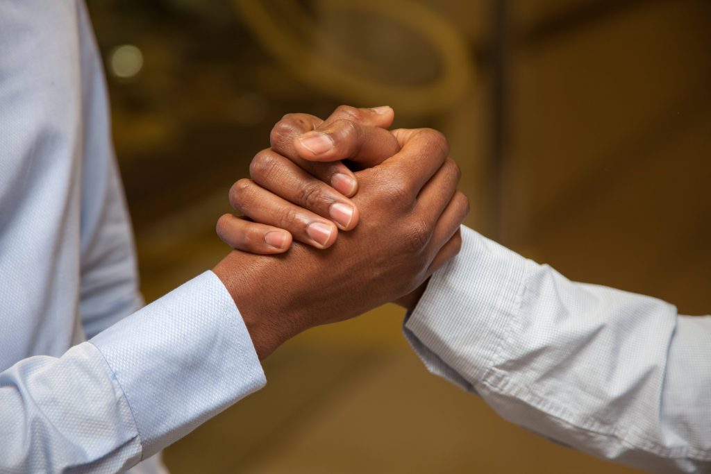 a close-up of two men's hands clasped