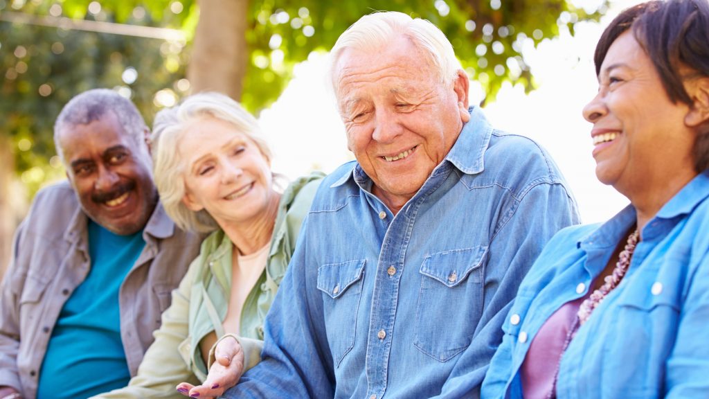 a happy group of older people, perhaps friends, laughing and smiling with each other