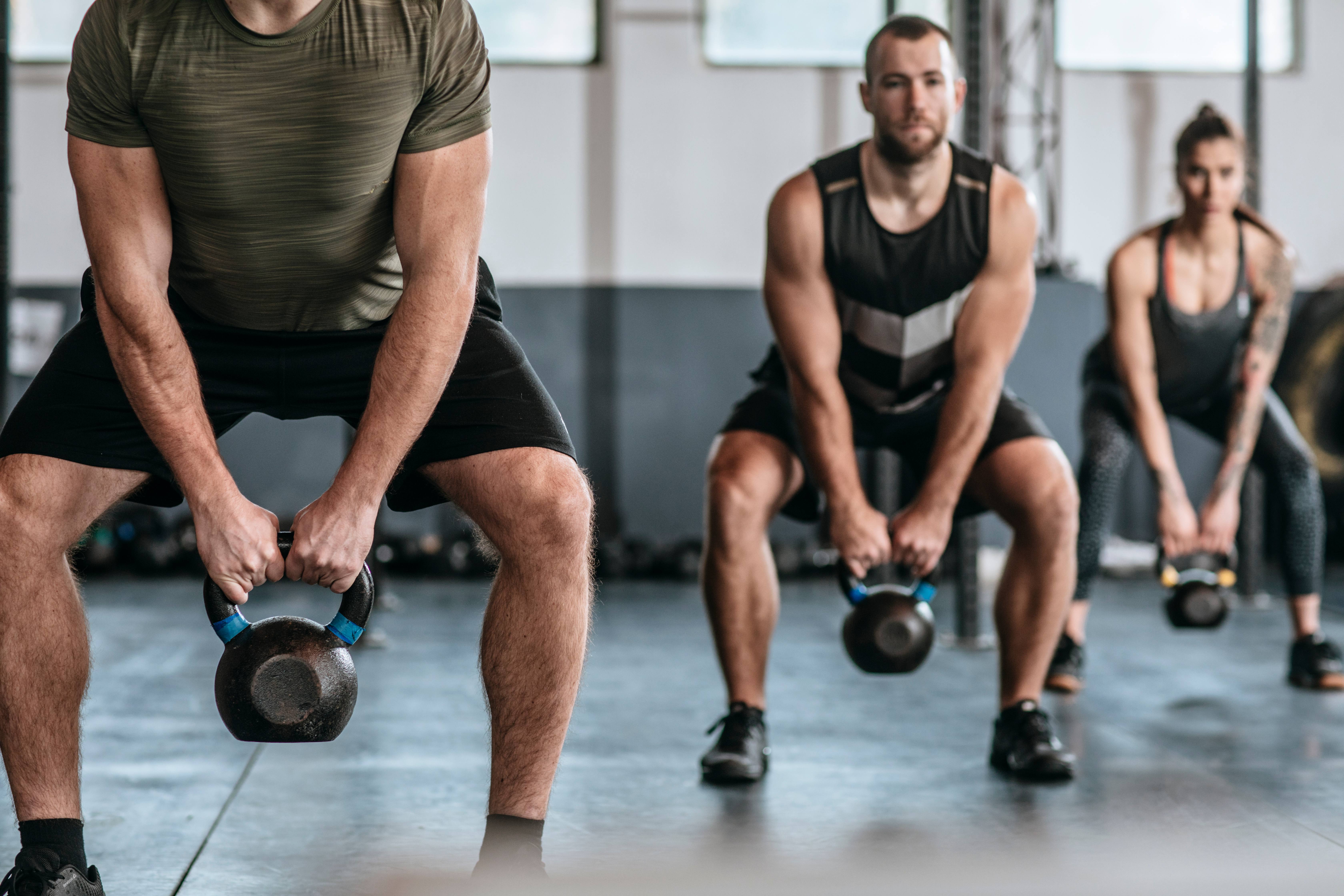 Group of people lifting kettlebells at gym