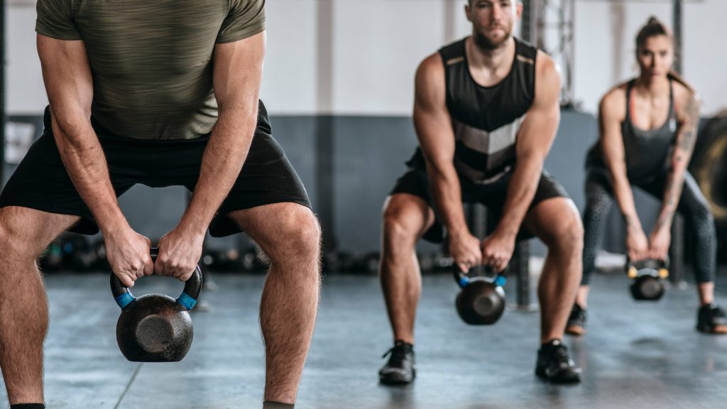 Un grupo de gente levanta pesas rusas en el gimnasio