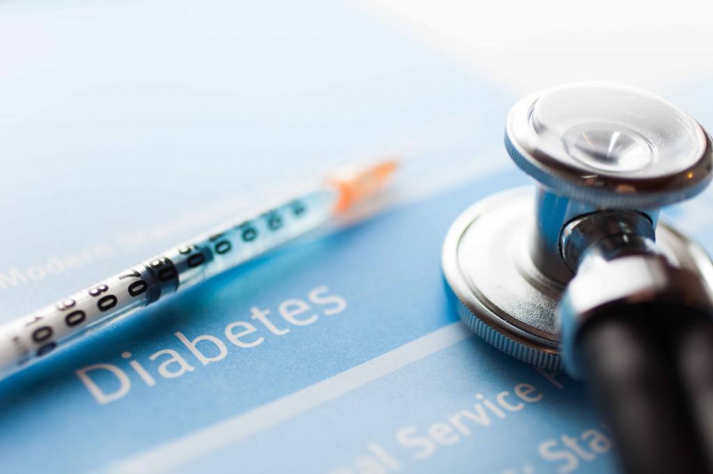 insulin needle, stethoscope and paper with the word diabetes