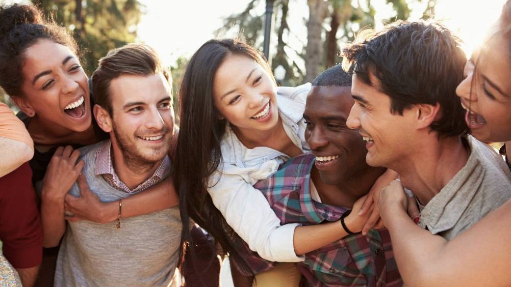 a diverse group of young people hugging and laughing, having fun shutterstock_172218053