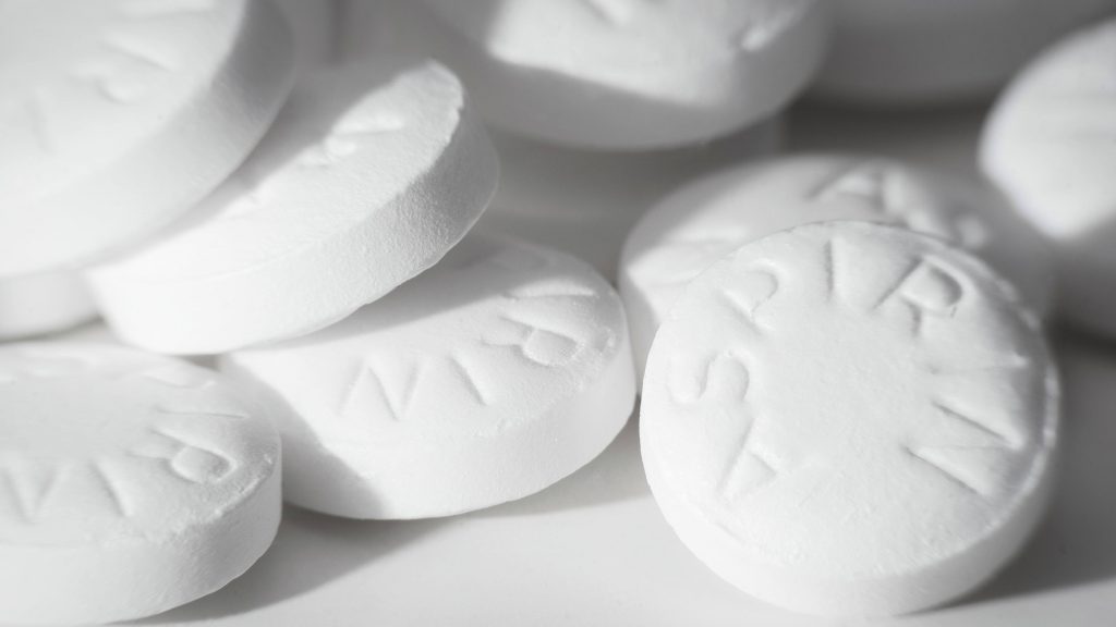 several aspirin tablets spilled on a white surface - pain medicine