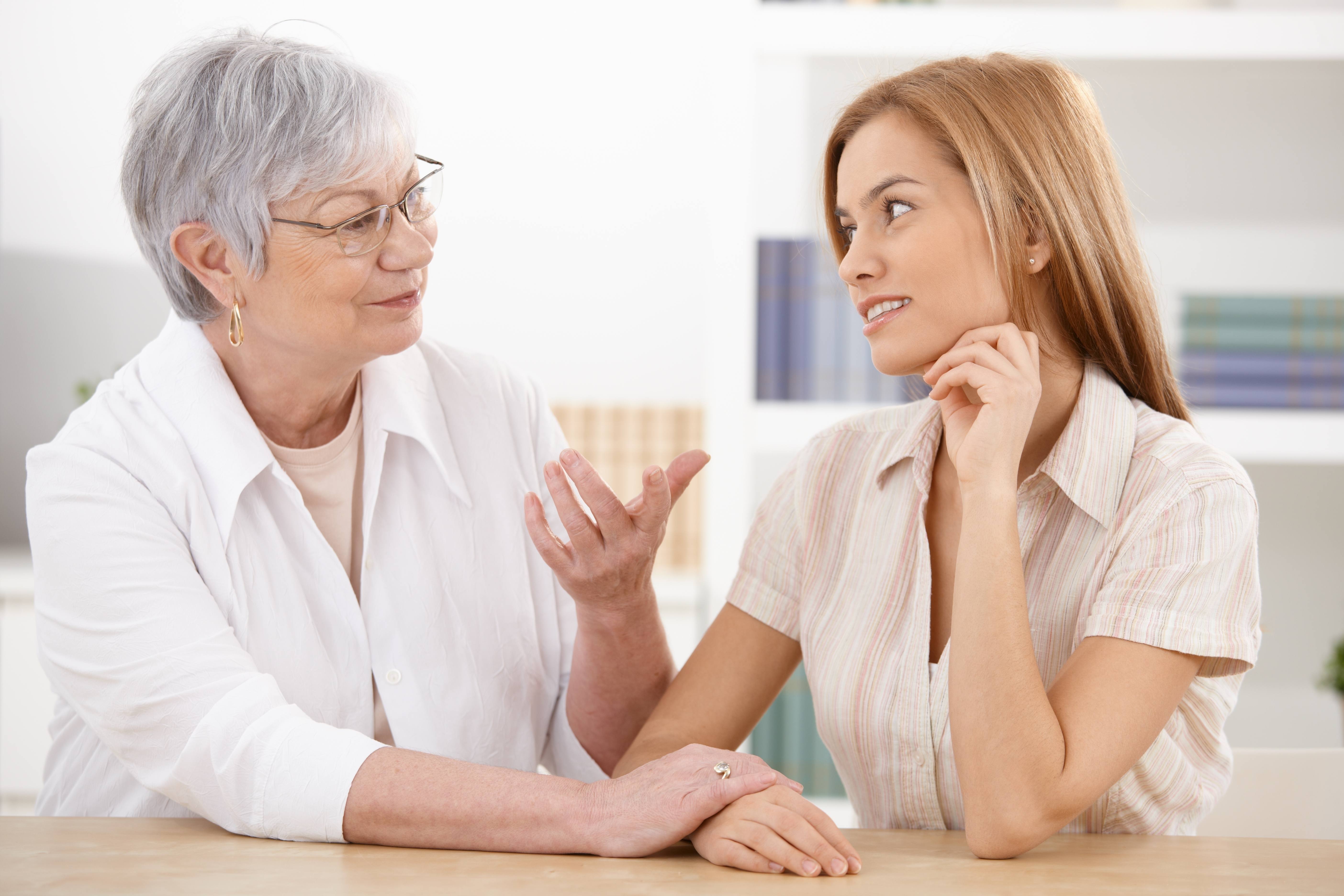 older woman talking with younger woman at table
