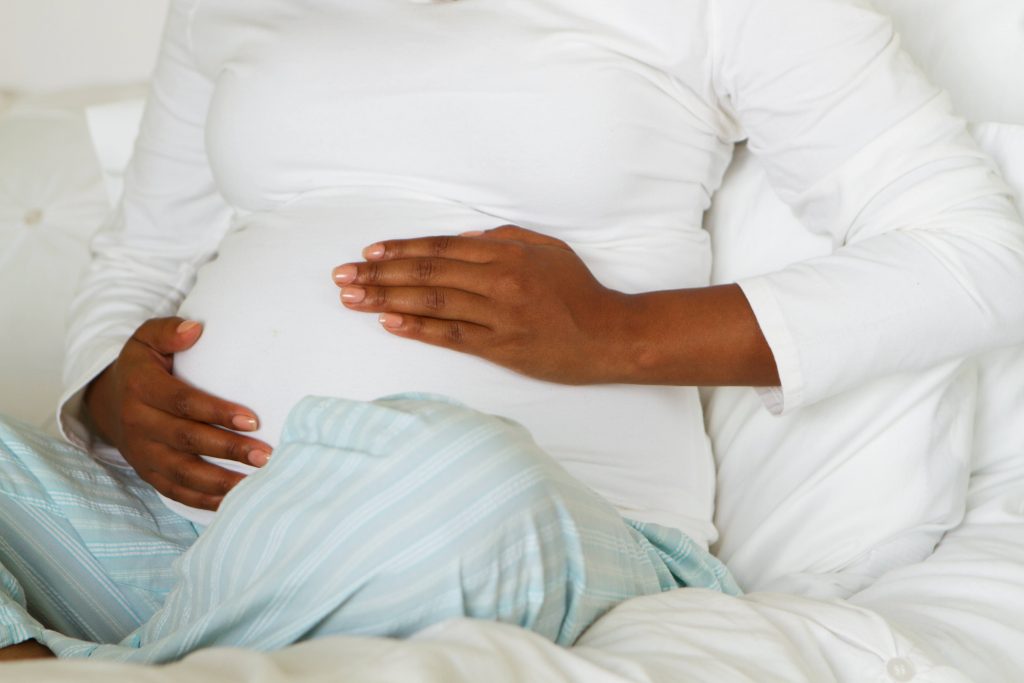 Pregnant woman holding her stomach.