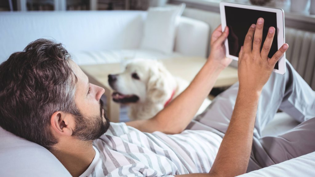 Hombre usando tableta digital en la sala de estar en casa