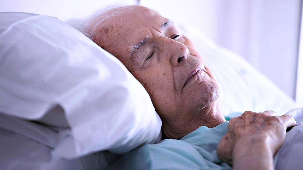 older, aging man in bed, sick, sleeping or dying