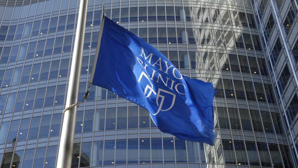 the blue and white Mayo Clinic shields flag flying outside the Gonda building windows in Rochester Minnesota