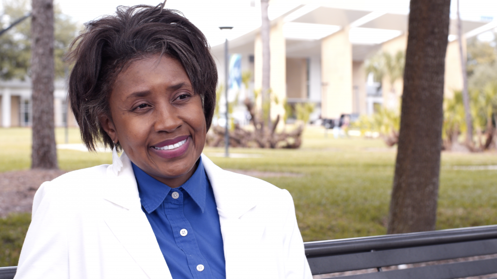 Mayo Clinic Florida eye sight patient Sandra Blue outside in a blue blouse, white jacket and smiling
