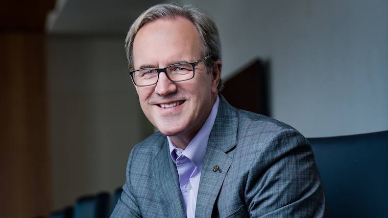 environmental picture of Ecolab CEO Douglas M. Baker, Jr., in a business suit, wearing glasses and smiling