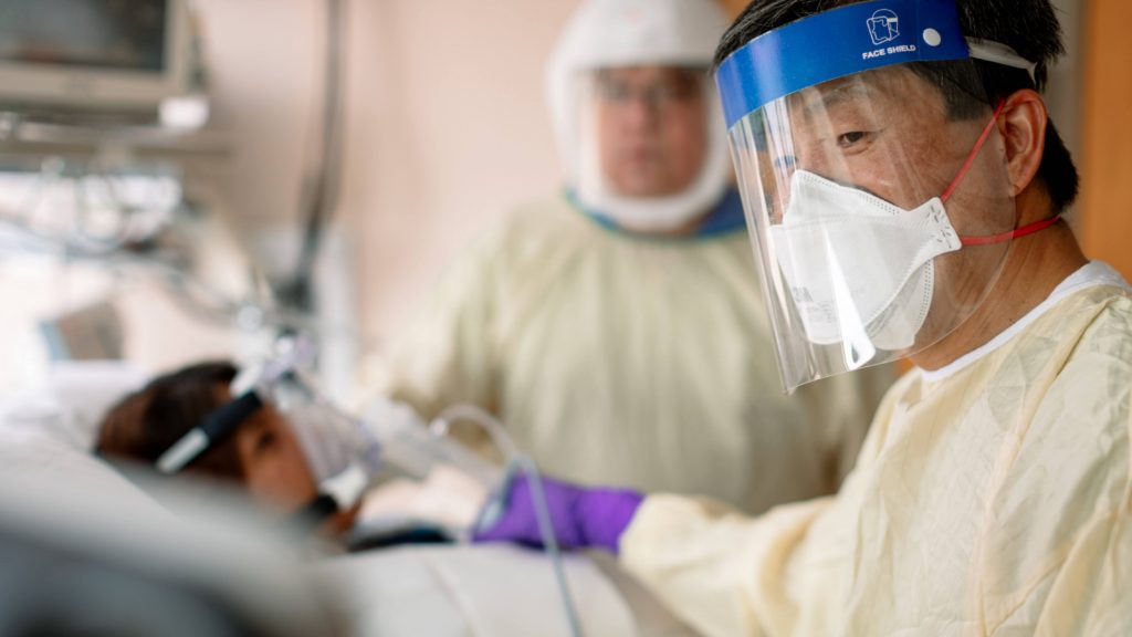 Mayo Clinic Intensive Care Unit medical personnel wearing PPE, personal protective equipment, helping a COVID-19 patient breathe on a ventilator in the ICU