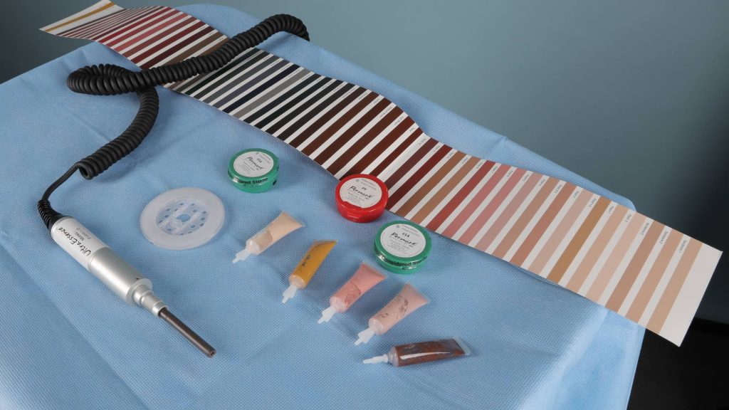 a surgerical tray with tattoo needle and different colored paints