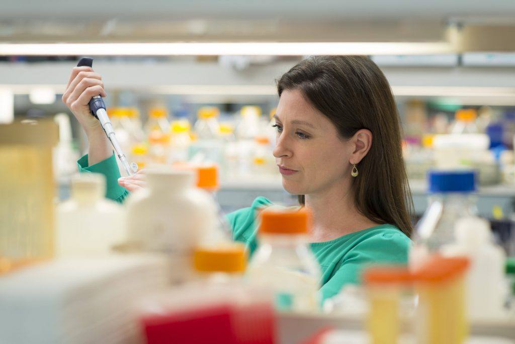 La Dra. Tania Gendron en un laboratorio de investigación trabajando midiendo líquidos