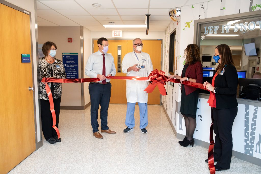 four NICU staff cutting red ribbon for opening of new space