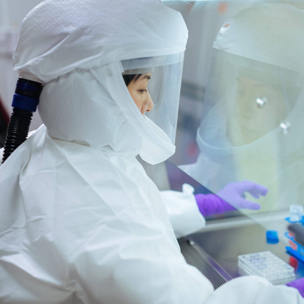 Mayo Clinic's Satoko Yamaoka, Ph.D., wearing enhanced PPE including a powered air-purifying respirator, working in the BSL-3 lab during COVID-19 virus research
