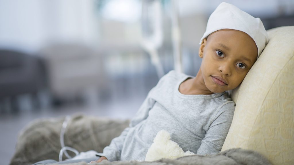a young Black, maybe Asian, child in the hospital with an IV, perhaps sick with cancer