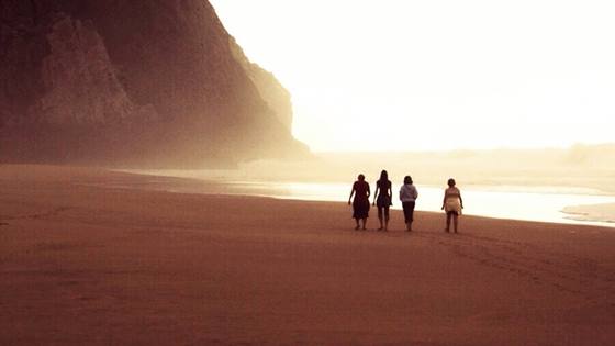 Cuatro personas caminan por la playa