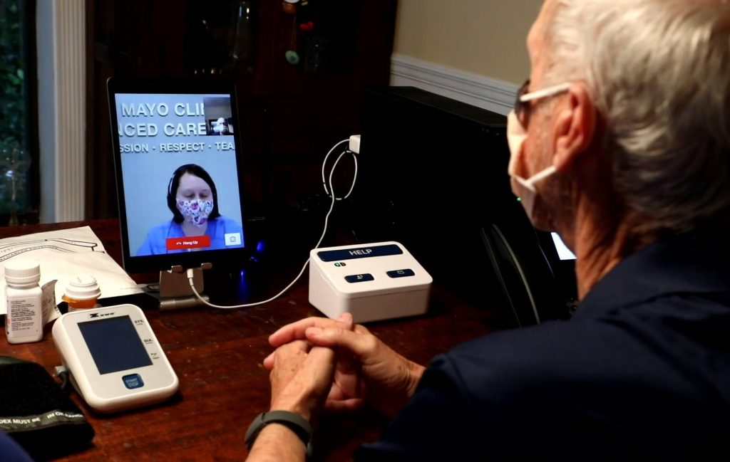 patient John Jolly on a video call with a nurse while in his home