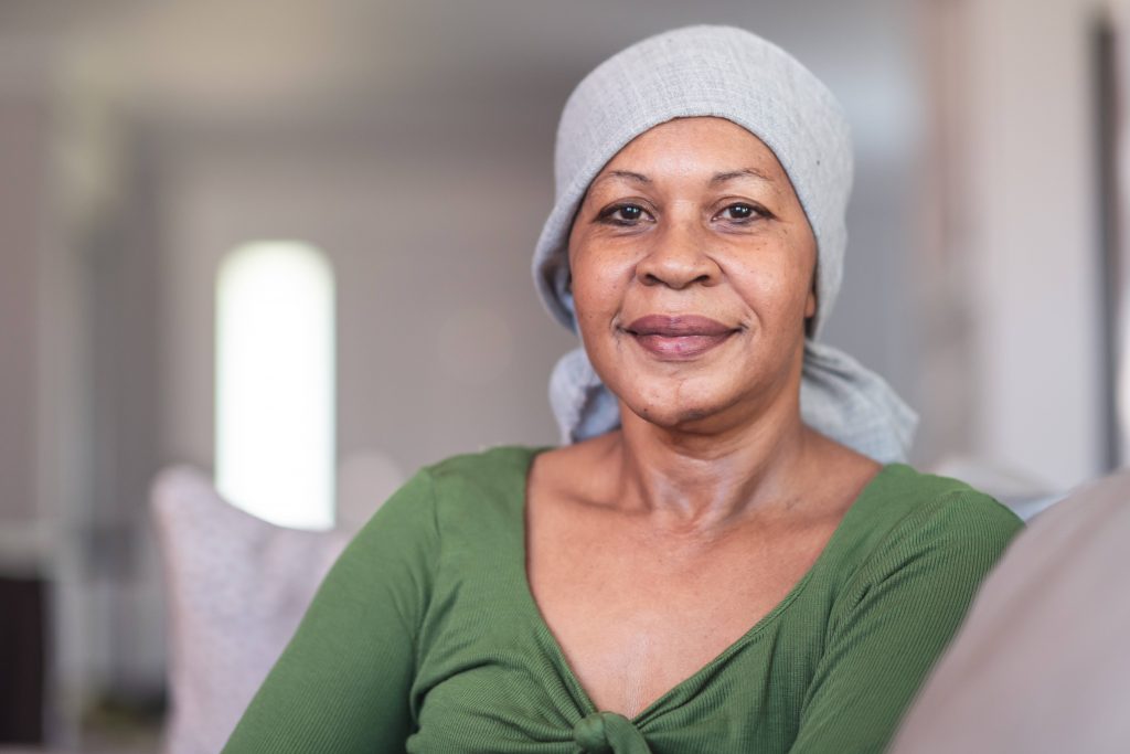 a middle aged Black woman, wearing a head scarf because of chemotherapy