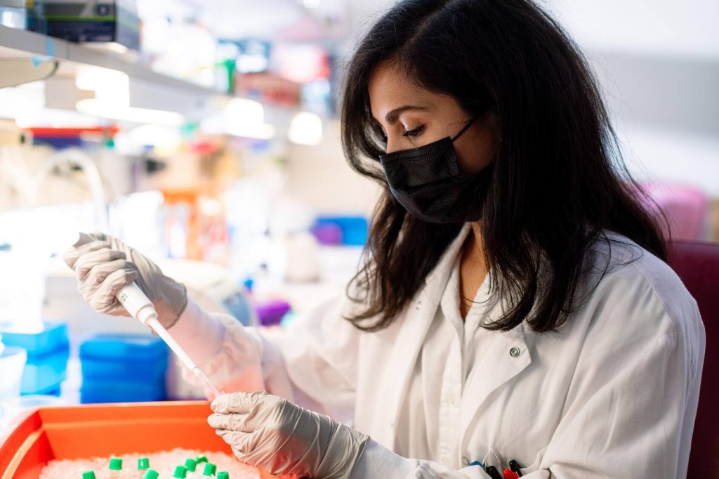 Female researcher at work station with pipette