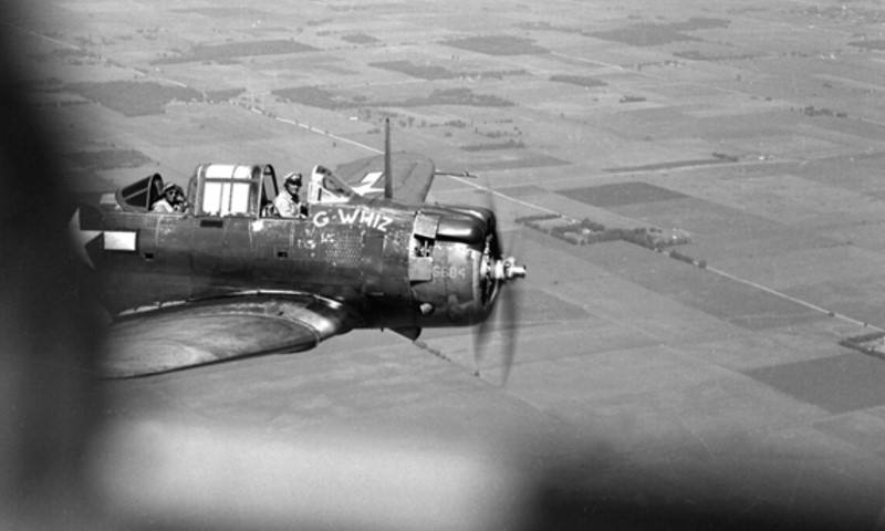a photograph taken from the air of G-Whiz, the Mayo Clinic Dauntless Dive Bomber plane used for testing the G-suit and other innovations